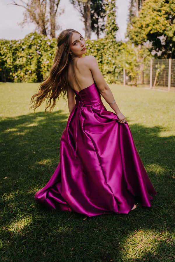 Vestido magenta girando sobre o gramado.