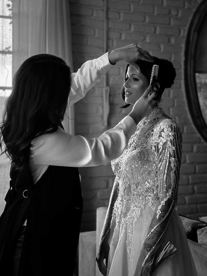 Preparação do penteado da noiva, em preto e branco.